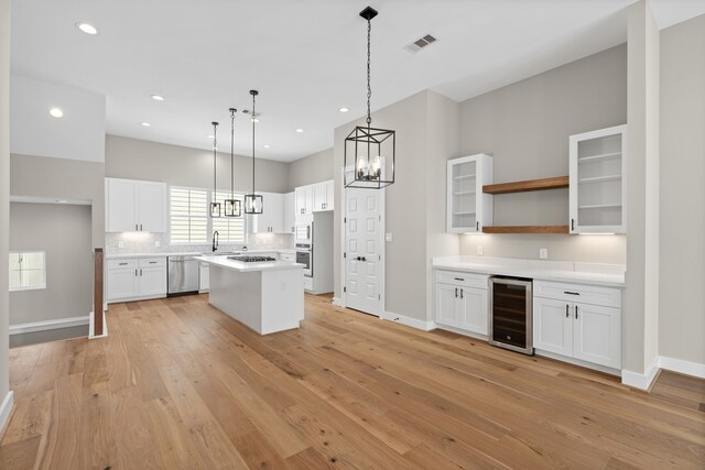 1139 W 22nd St, Houston, TX 77008 - kitchen featuring beverage cooler, stainless steel dishwasher, a sink, white cabinetry, and light wood-style floors