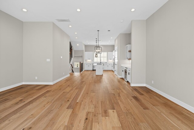 1139 W 22nd St, Houston, TX 77008 - unfurnished living room featuring light wood-style floors, baseboards, recessed lighting, and a chandelier