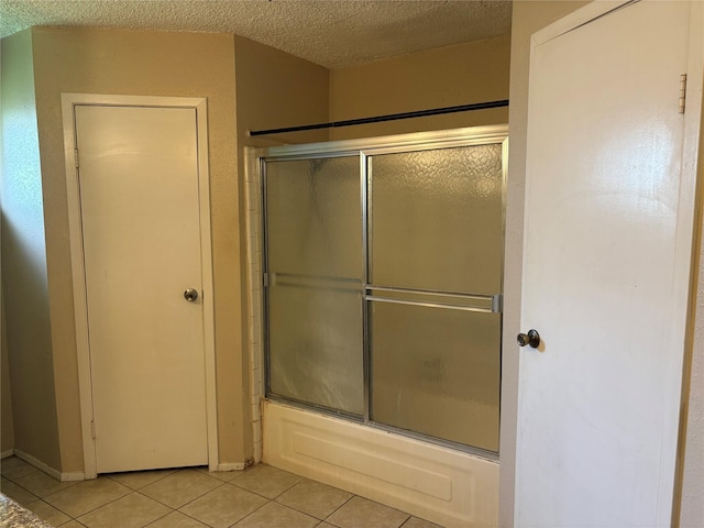 4934 Deerwood Cir, Baytown, TX 77521 - bathroom with tile patterned flooring, shower / bath combination with glass door, and a textured ceiling