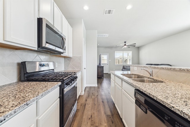 3685 Cub Dr, Conroe, TX 77301 - kitchen featuring appliances with stainless steel finishes, a sink, dark wood-style floors, ceiling fan, and white cabinets