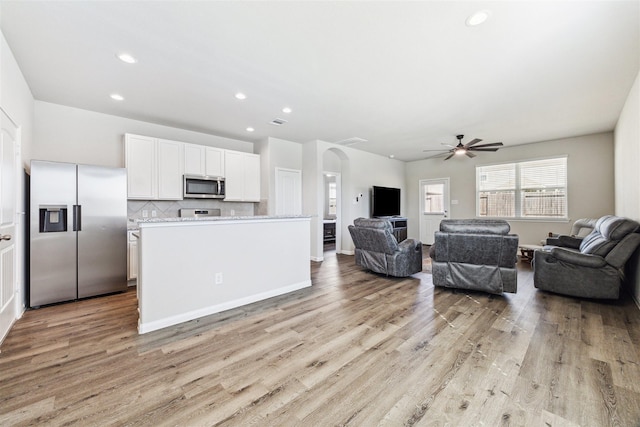 3685 Cub Dr, Conroe, TX 77301 - living area with light wood-style floors, a ceiling fan, recessed lighting, and arched walkways