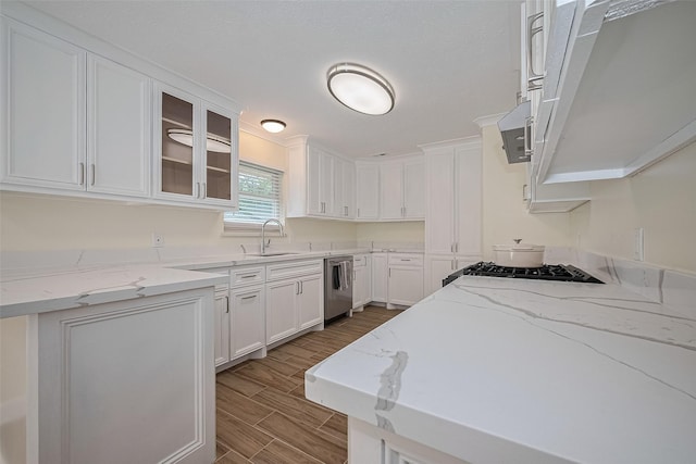 7130 Walkway St, Houston, TX 77036 - kitchen with stainless steel dishwasher, a sink, white cabinetry, and wood tiled floors