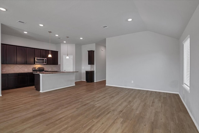 2314 Brickfielder Ln, Baytown, TX 77523 - kitchen featuring stainless steel appliances, tasteful backsplash, open floor plan, light wood-type flooring, and an island with sink