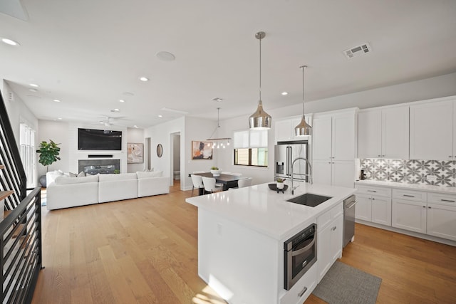 828 Wakefield Dr Unit B, Houston, TX 77018 - kitchen featuring a sink, appliances with stainless steel finishes, recessed lighting, backsplash, and light wood finished floors