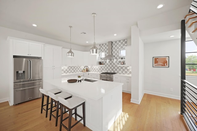 828 Wakefield Dr Unit B, Houston, TX 77018 - kitchen with high quality appliances, a sink, wall chimney exhaust hood, tasteful backsplash, and a breakfast bar area