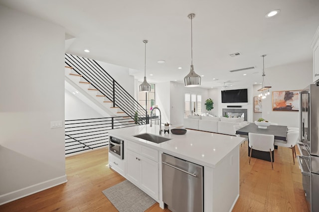 828 Wakefield Dr Unit B, Houston, TX 77018 - kitchen featuring stainless steel appliances, a sink, white cabinetry, light wood-type flooring, and recessed lighting