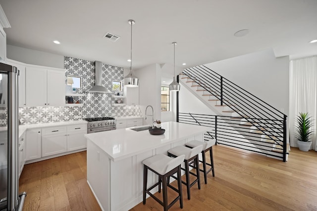 828 Wakefield Dr Unit B, Houston, TX 77018 - kitchen featuring a sink, stainless steel appliances, open shelves, light wood-style floors, and decorative backsplash