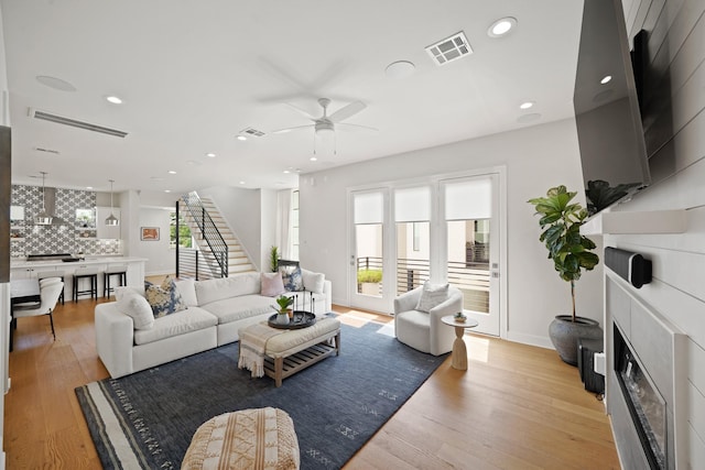 828 Wakefield Dr Unit B, Houston, TX 77018 - living room featuring light wood-type flooring, ceiling fan, stairs, a fireplace, and recessed lighting