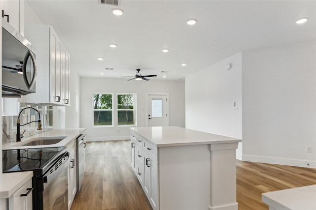3708 Avenue S, Santa Fe, TX 77510 - kitchen featuring appliances with stainless steel finishes, a sink, light wood-style flooring, a ceiling fan, and recessed lighting
