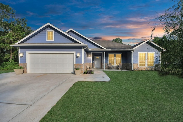 25450 Killarney St, Hempstead, TX 77445 - single story home with driveway, stone siding, a lawn, a porch, and a garage