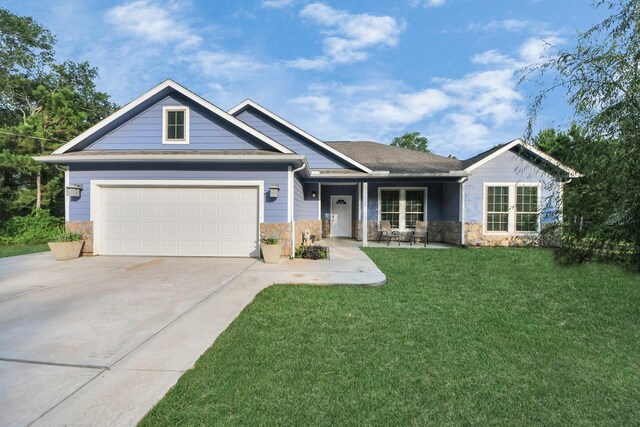 25450 Killarney St, Hempstead, TX 77445 - view of front of home with driveway, stone siding, a front lawn, a garage, and covered porch