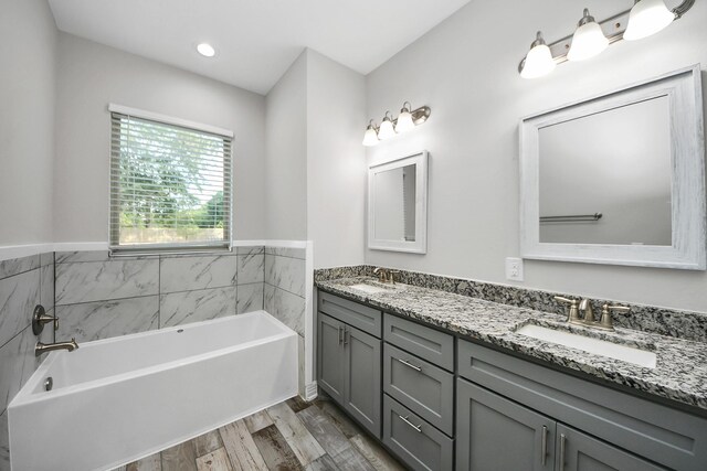 25450 Killarney St, Hempstead, TX 77445 - full bathroom featuring double vanity, a bath, and wood finished floors
