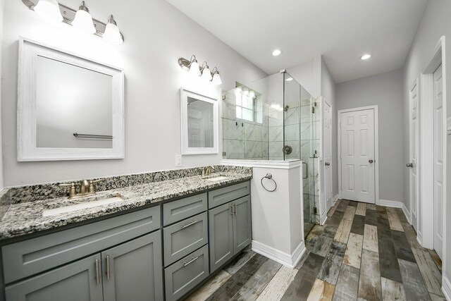 25450 Killarney St, Hempstead, TX 77445 - bathroom featuring double vanity, a stall shower, wood finished floors, baseboards, and recessed lighting