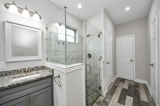 25450 Killarney St, Hempstead, TX 77445 - bathroom featuring a stall shower, vanity, wood finished floors, recessed lighting, and baseboards