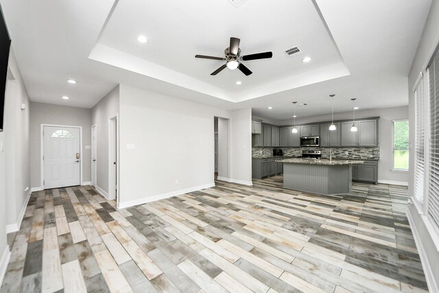 25450 Killarney St, Hempstead, TX 77445 - kitchen with gray cabinets, appliances with stainless steel finishes, a raised ceiling, backsplash, and recessed lighting