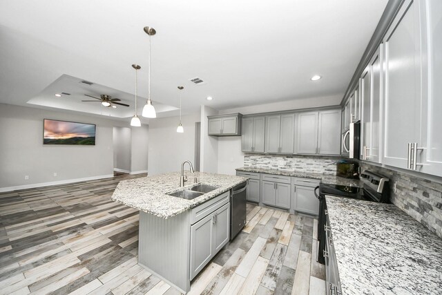 25450 Killarney St, Hempstead, TX 77445 - kitchen featuring a sink, gray cabinetry, appliances with stainless steel finishes, light stone counters, and recessed lighting