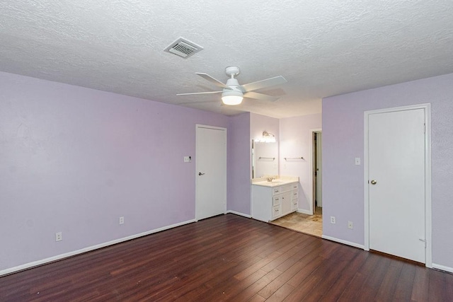 6310 Gleneagles Dr, Pasadena, TX 77505 - unfurnished bedroom featuring wood finished floors, a textured ceiling, connected bathroom, and a ceiling fan