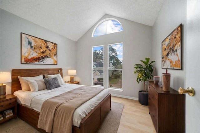 3317 Golden Trails Dr Unit 802, Houston, TX 77345 - bedroom with lofted ceiling, light wood-type flooring, and a textured ceiling