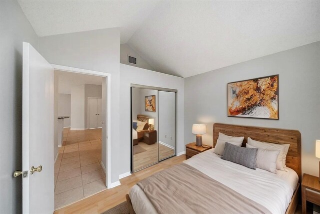 3317 Golden Trails Dr Unit 802, Houston, TX 77345 - bedroom with a closet, vaulted ceiling, light wood-style flooring, and baseboards