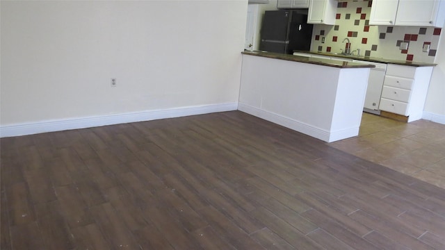 2223 Sentinal Oaks St, Sugar Land, TX 77478 - kitchen featuring freestanding refrigerator, dark wood-style flooring, dark countertops, white dishwasher, and baseboards