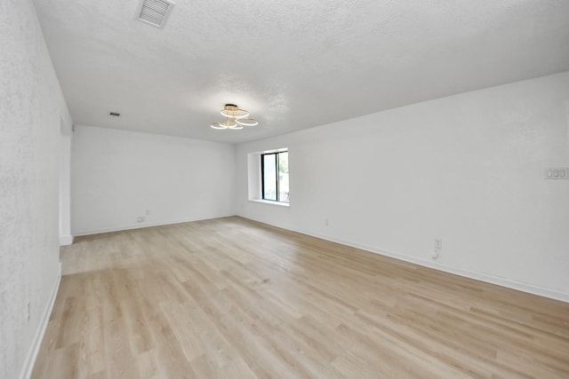 3223 Deer Valley Dr, Spring, TX 77373 - unfurnished room with light wood finished floors, a chandelier, baseboards, and a textured ceiling
