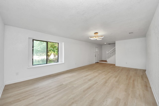 3223 Deer Valley Dr, Spring, TX 77373 - unfurnished room with light wood finished floors, a chandelier, stairway, and baseboards