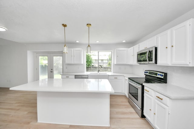 3223 Deer Valley Dr, Spring, TX 77373 - kitchen featuring appliances with stainless steel finishes, a sink, a kitchen island, white cabinetry, and recessed lighting