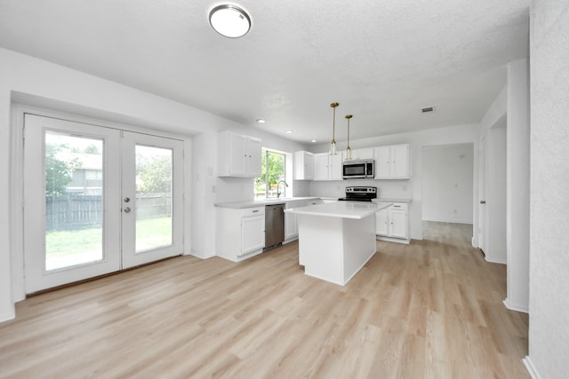 3223 Deer Valley Dr, Spring, TX 77373 - kitchen with appliances with stainless steel finishes, french doors, light wood-type flooring, white cabinetry, and light countertops