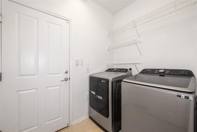 13600 Breton Ridge St Unit 24A, Houston, TX 77070 - laundry area with washing machine and clothes dryer, light tile patterned floors, and baseboards