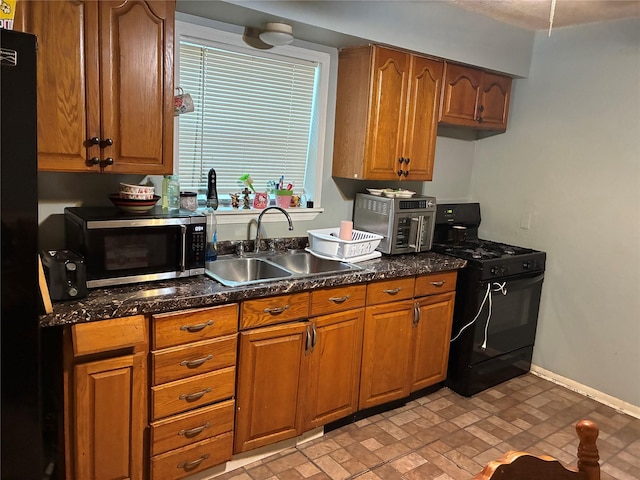 4114 Averill St, Houston, TX 77009 - kitchen featuring black appliances, a sink, brown cabinetry, and baseboards