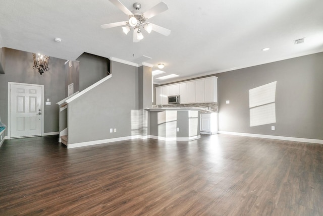 17139 Oakwood Chase Dr, Spring, TX 77379 - unfurnished living room featuring dark wood-style floors, baseboards, a ceiling fan, a chandelier, and ornamental molding