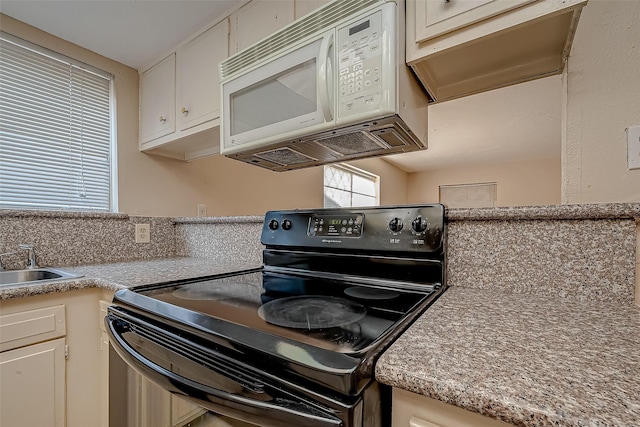 7650 Smiling Wood Ln, Houston, TX 77086 - kitchen with black / electric stove, white microwave, a sink, light countertops, and white cabinetry
