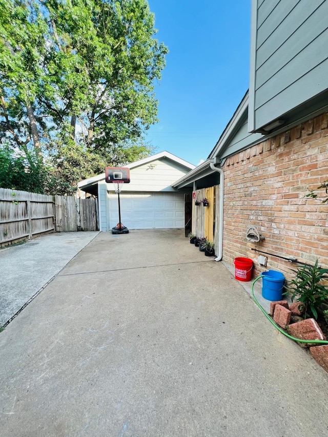 6639 Seaton Valley Dr, Spring, TX 77379 - view of side of property featuring brick siding, concrete driveway, an outdoor structure, and a garage