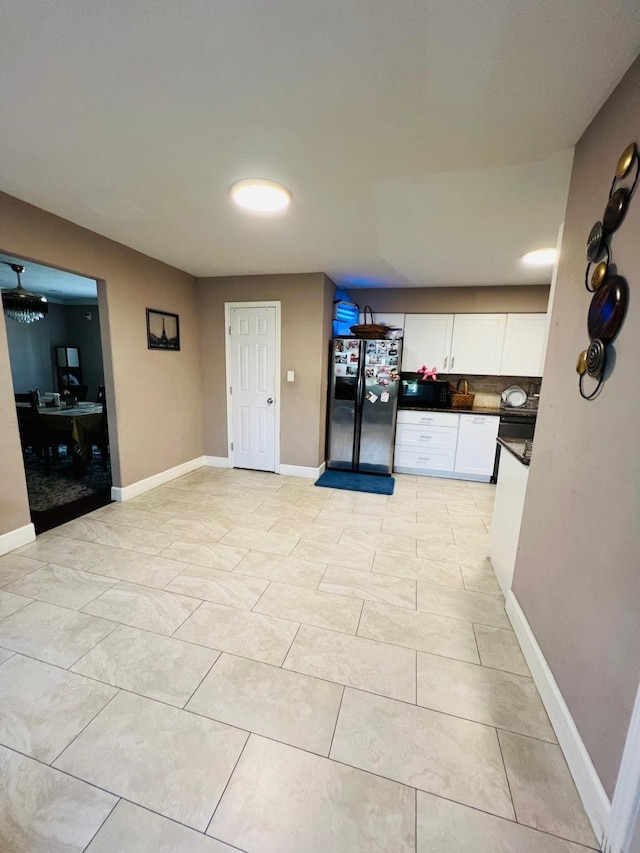 6639 Seaton Valley Dr, Spring, TX 77379 - kitchen featuring stainless steel refrigerator with ice dispenser, white cabinets, decorative backsplash, dark countertops, and black microwave
