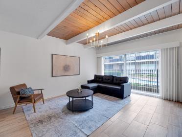 3809 N Braeswood Unit 14, Houston, TX 77025 - living room with a chandelier and wood ceiling with exposed beams