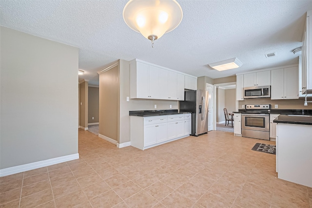 3705 Autumn Ln, Baytown, TX 77521 - kitchen featuring appliances with stainless steel finishes, dark countertops, a sink, a textured ceiling, and white cabinetry