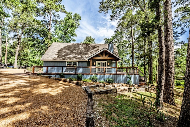 44 Post Oak Dr, Huntsville, TX 77320 - view of front of house with a wooden deck, a shingled roof, a chimney, and stairway