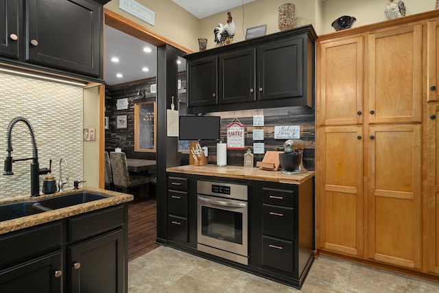 1802 Snow Goose Ln, Katy, TX 77493 - kitchen with stainless steel oven, a sink, decorative backsplash, dark cabinetry, and recessed lighting
