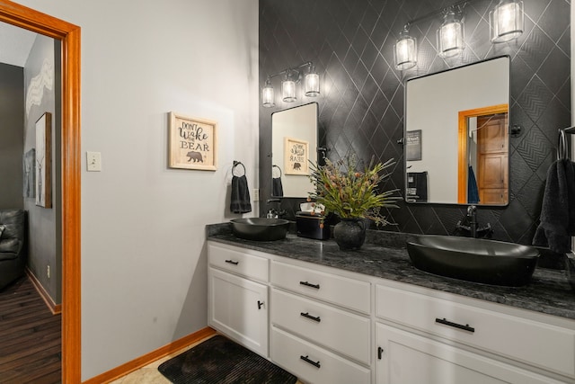 1802 Snow Goose Ln, Katy, TX 77493 - bathroom featuring double vanity, backsplash, wood finished floors, and baseboards