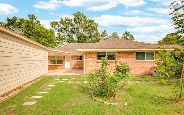 2706 Williams Grant St, Sugar Land, TX 77479 - back of property featuring brick siding, a patio area, a yard, and a shingled roof