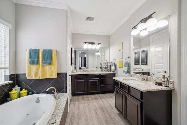 12226 Brighton Brook Ln, Tomball, TX 77377 - bathroom featuring two vanities, plenty of natural light, crown molding, a jetted tub, and wood finished floors