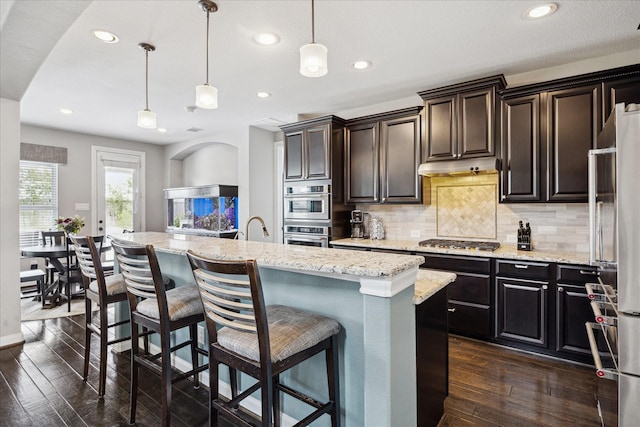 12226 Brighton Brook Ln, Tomball, TX 77377 - kitchen with stainless steel appliances, dark wood-style flooring, backsplash, recessed lighting, and a kitchen island with sink