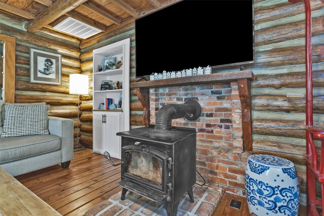 1356 Pegoda Ranch Rd, Woodlake, TX 75865 - living room with rustic walls, a wood stove, hardwood / wood-style floors, and wood ceiling with exposed beams