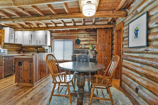 1356 Pegoda Ranch Rd, Woodlake, TX 75865 - dining area with wooden ceiling with exposed beams, hardwood / wood-style floors, and rustic walls