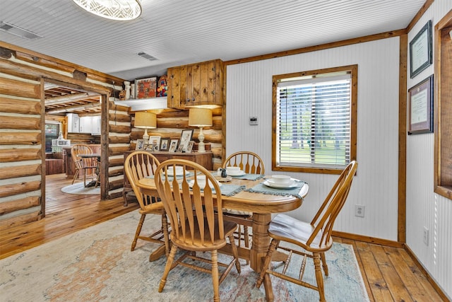 1356 Pegoda Ranch Rd, Woodlake, TX 75865 - dining room featuring log walls, hardwood / wood-style flooring, and baseboards
