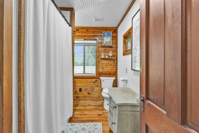 1356 Pegoda Ranch Rd, Woodlake, TX 75865 - full bathroom featuring toilet, wood walls, wood finished floors, vanity, and a shower with curtain