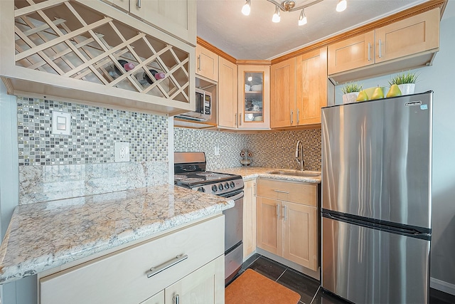 6102 Seawall Blvd Unit 252, Galveston, TX 77551 - kitchen with stainless steel appliances, a sink, backsplash, glass insert cabinets, and light brown cabinetry