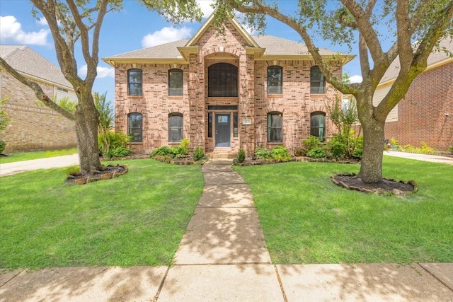 4910 Bayfair St, Pasadena, TX 77505 - view of front of house with brick siding, a front lawn, and a shingled roof