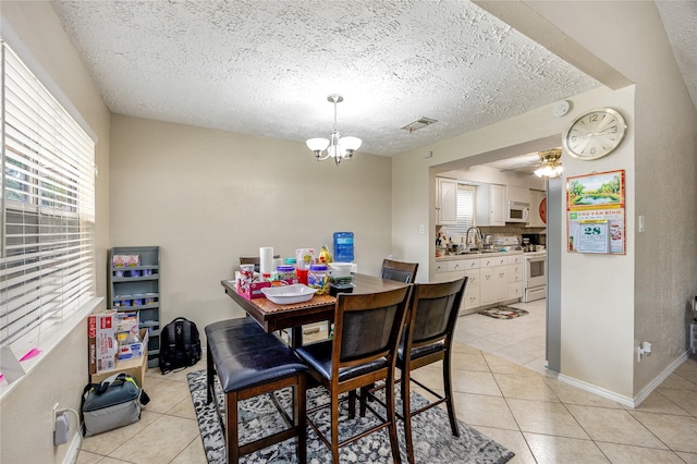 16307 Thistleglen Dr, Houston, TX 77095 - dining space featuring light tile patterned floors, a chandelier, a textured ceiling, a ceiling fan, and baseboards