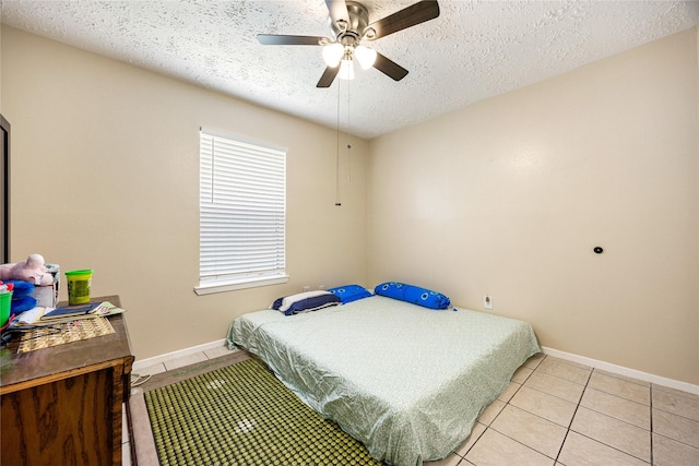 16307 Thistleglen Dr, Houston, TX 77095 - bedroom featuring a textured ceiling, baseboards, light tile patterned flooring, and a ceiling fan